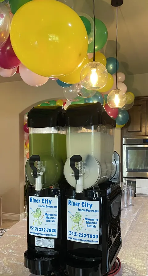 Two-flavor margarita machine set up for a party with balloons