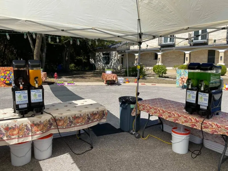 Two margarita machines under a tent at an outdoor event