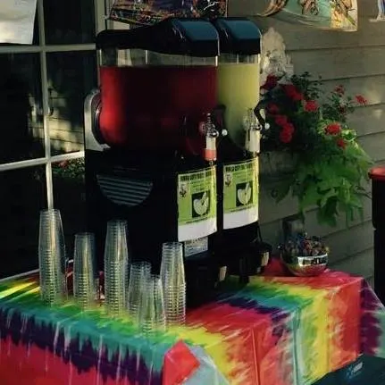 Margarita machine with cups on a colorful party table